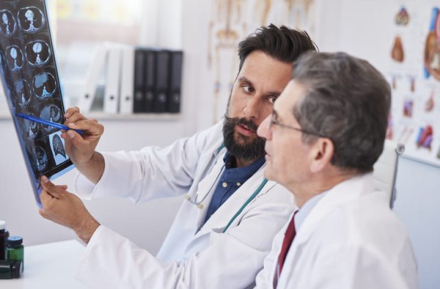 medici discuta despre diagnosticul unui pacient