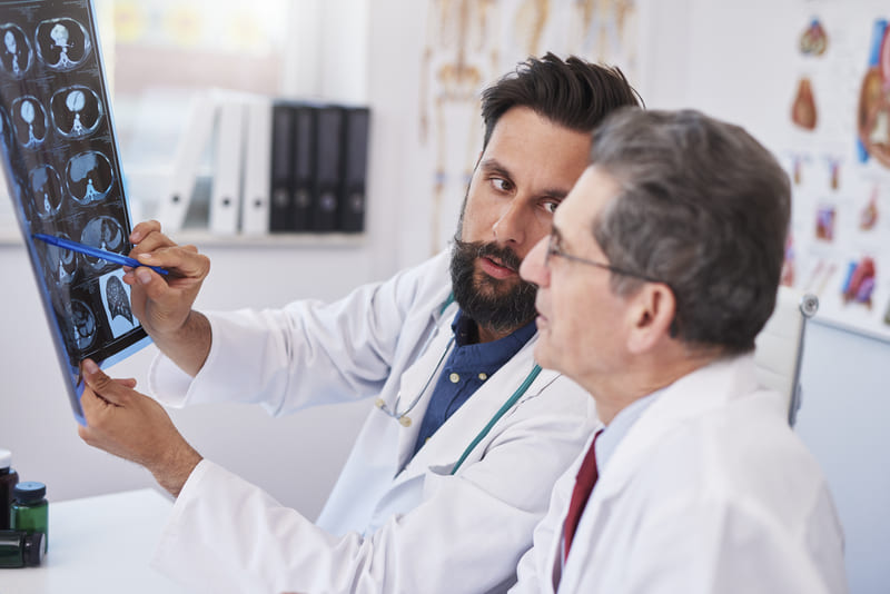 medici discuta despre diagnosticul unui pacient