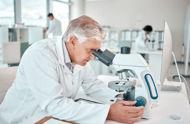 medic examineaza proba la microscop